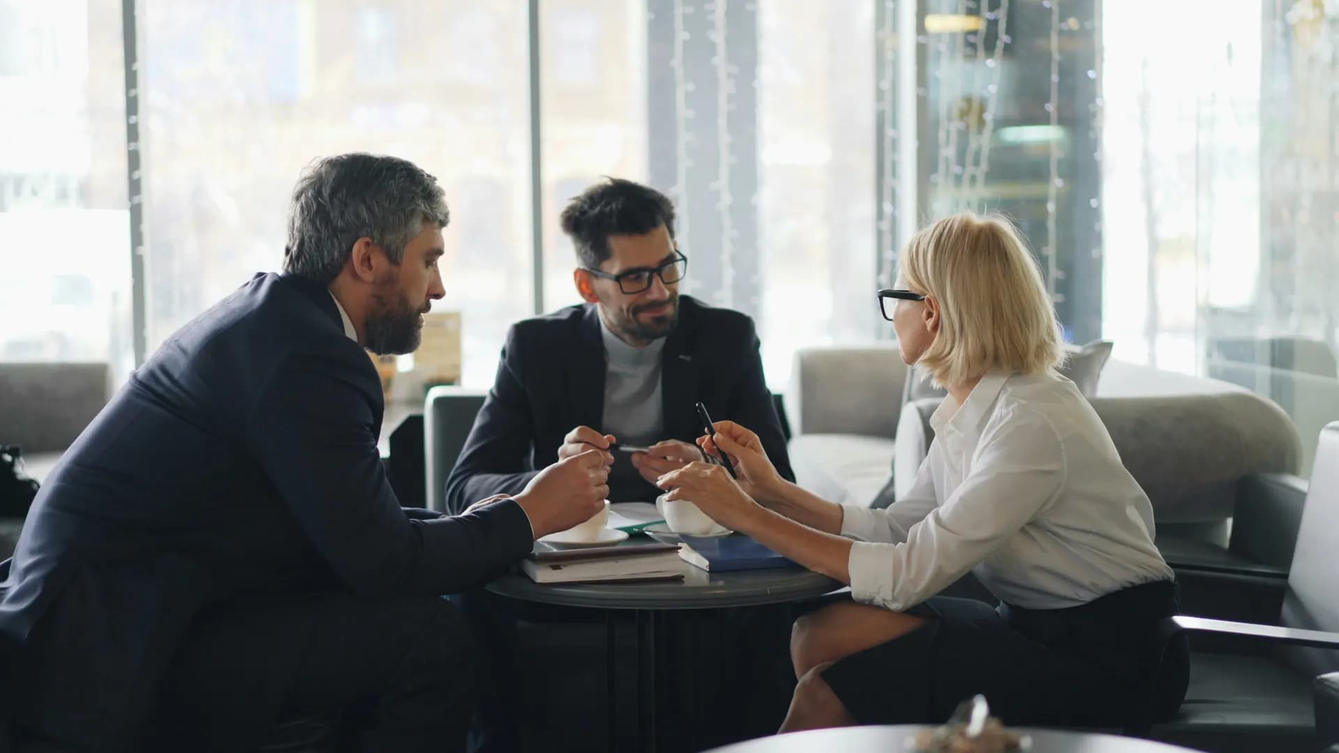 Three colleagues talking around a small table